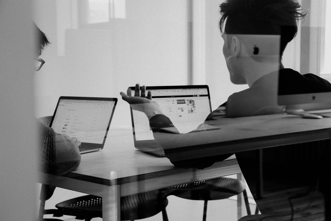 Two people reviewing strategy on laptops
